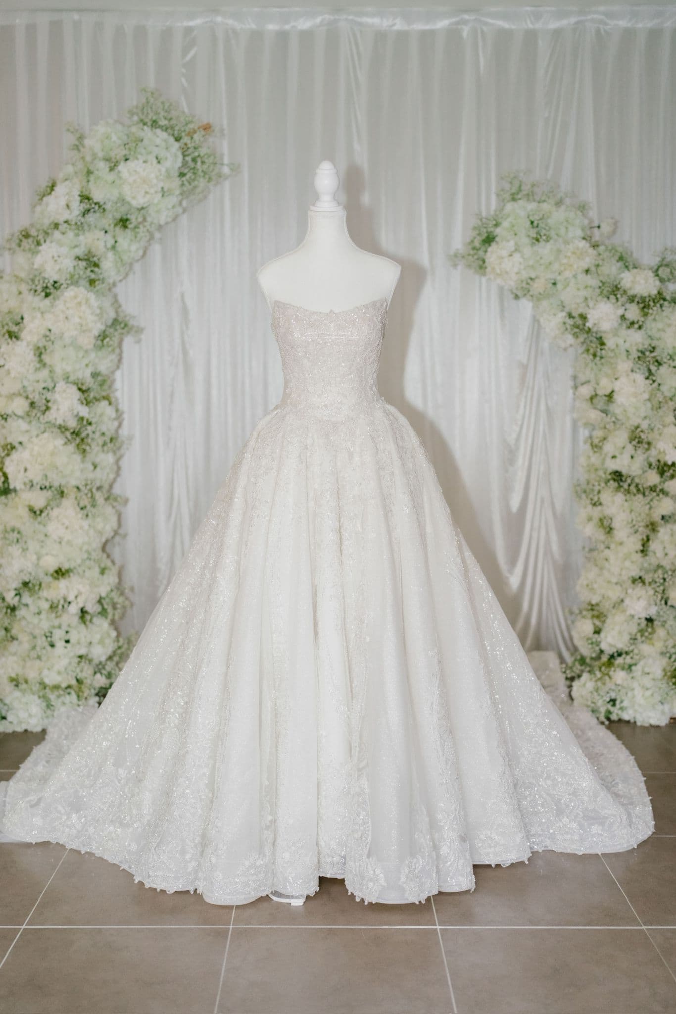 Wedding dress on mannequin with floral arches