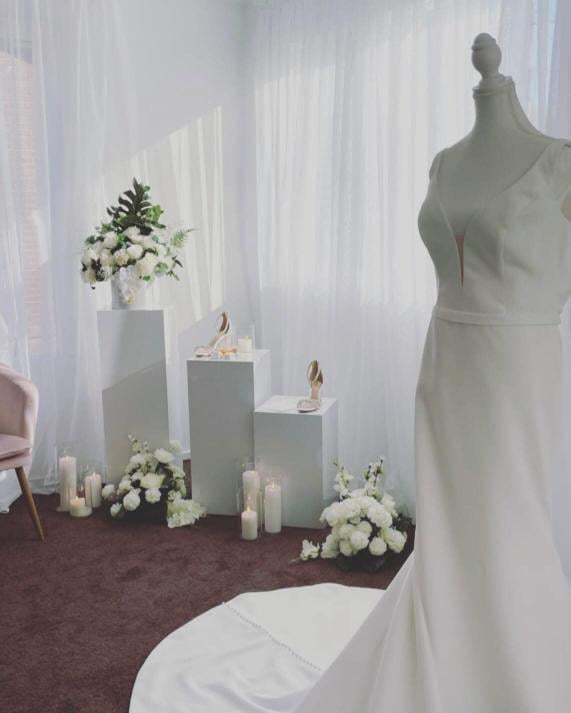Bride room with mannequin, plinths, candles and backdrop