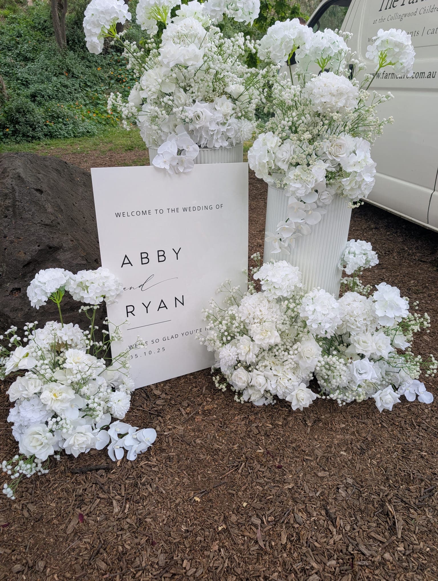 Welcome sign with white floral arrangements for Abby and Ryan