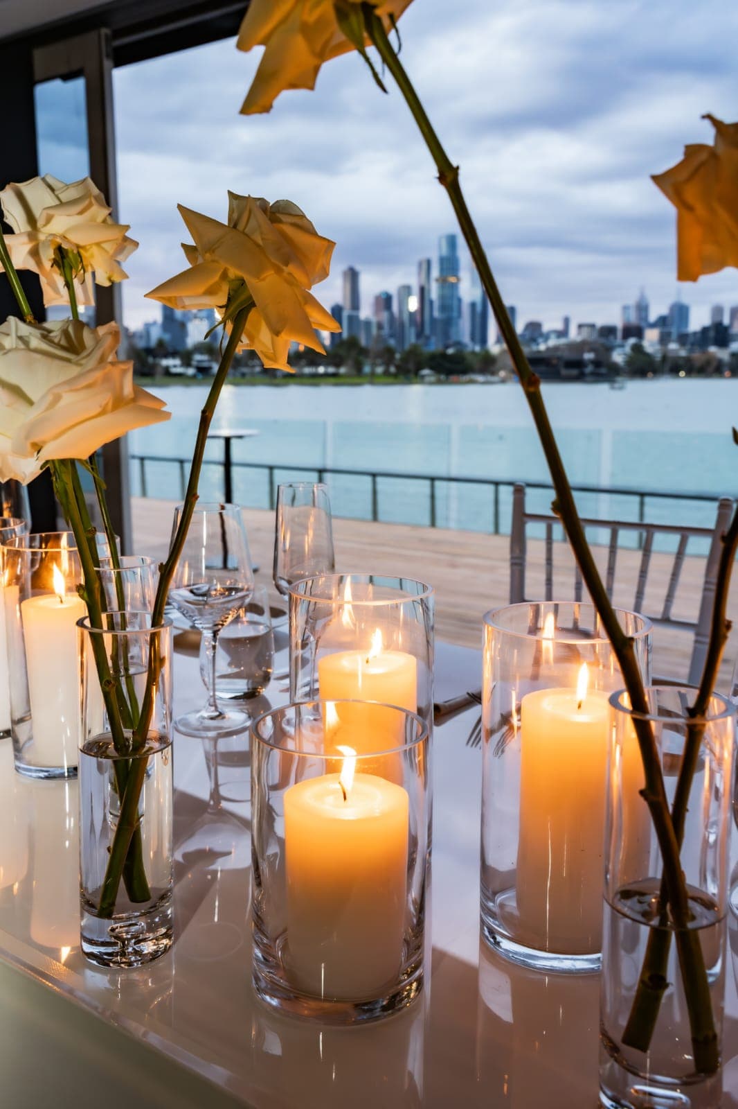 Waterfront banquet tables with candlelight at dusk