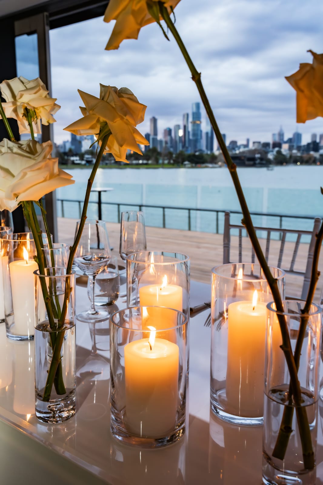 Pillar candles and roses with city skyline at dusk